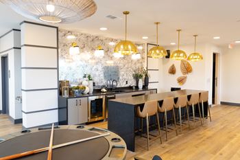 A modern kitchen with a black countertop and white cabinets.